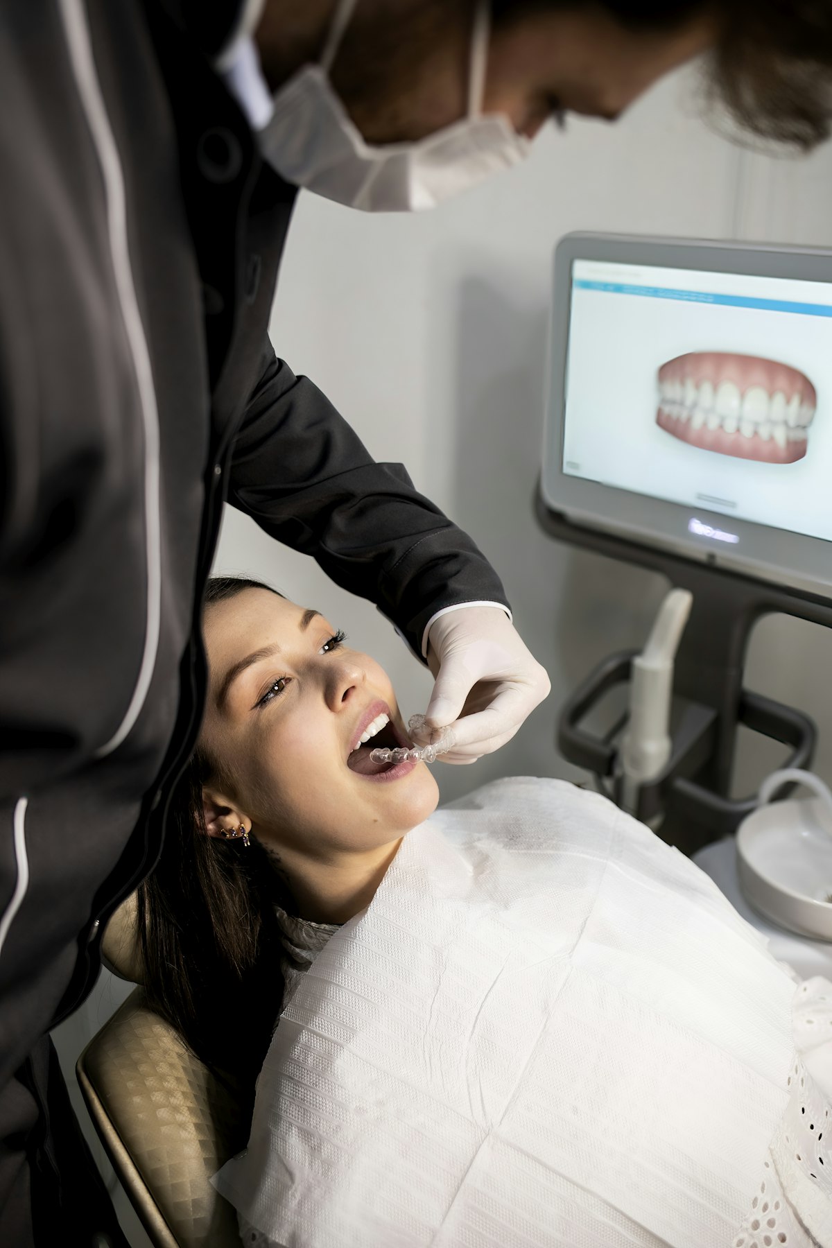 Odontólogo revisando paciente con escáner dental después de extracción