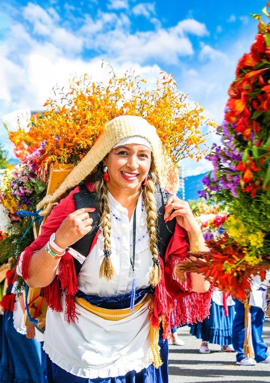 Silletera vestida con traje tradicional cargando una silleta de flores durante el Desfile de Silleteros en Medellín