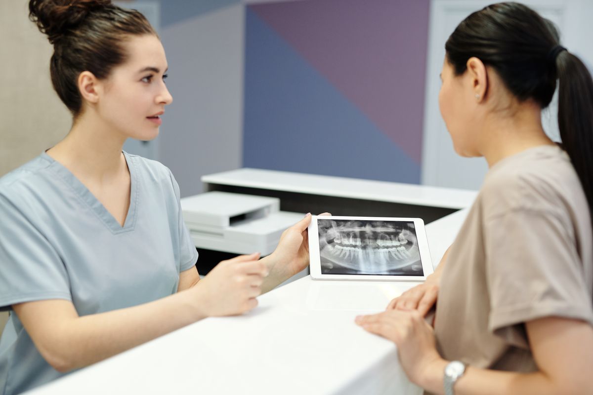 Odontóloga explicando una radiografía panorámica dental a una paciente